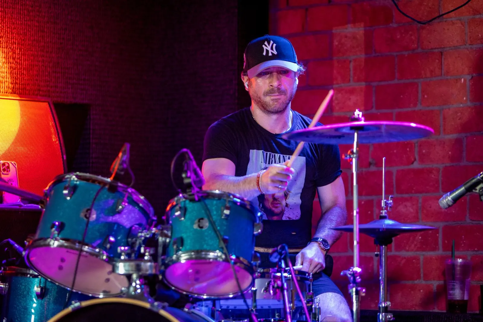 A drummer under red and blue stage light at the Black Star Polo Bene-Fest